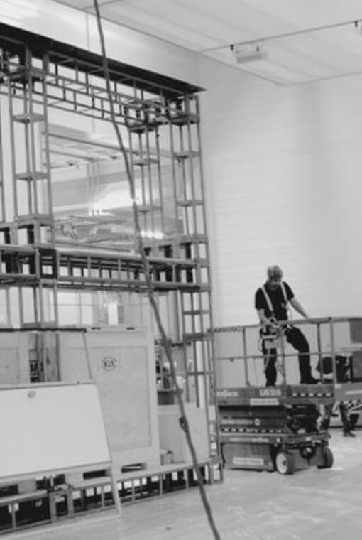 Man standing on scissor lift in black and white